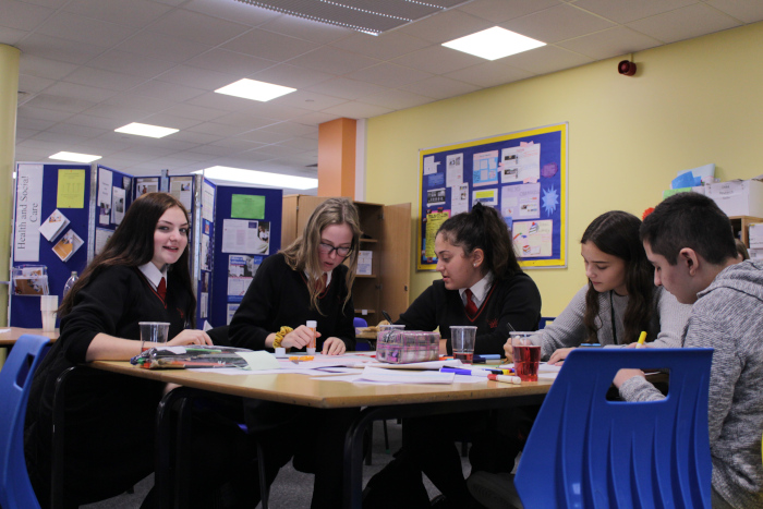 QKA and visiting students working at a desk